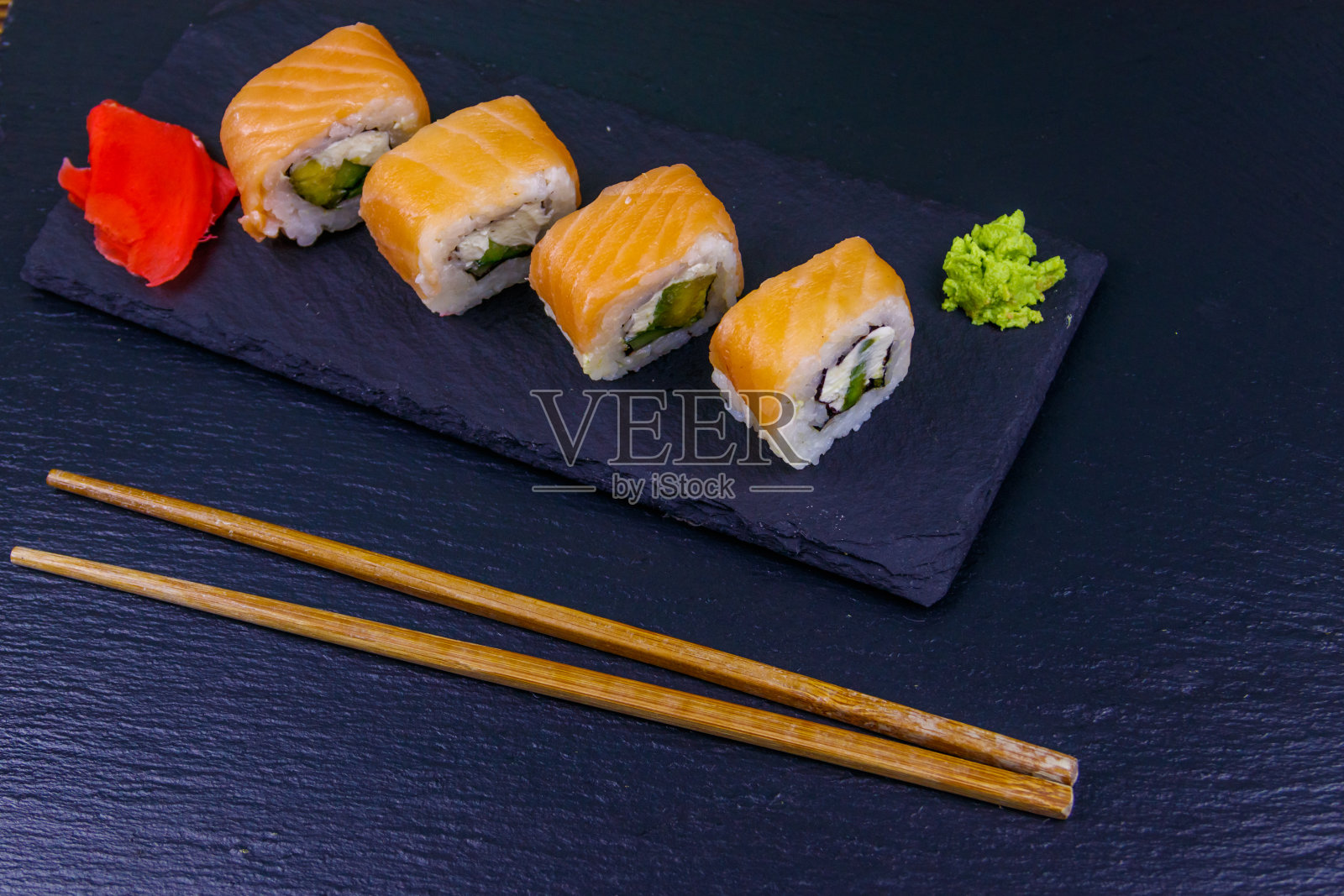 寿司把费城卷在黑石板上照片摄影图片