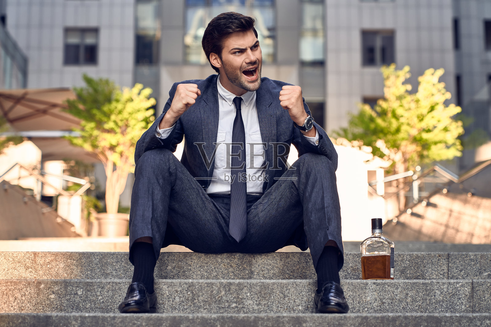 焦急的商人坐在台阶上。压力大的商人头痛，垂头丧气的感觉。商业问题，被解雇，失业，因covid-19而破产。照片摄影图片