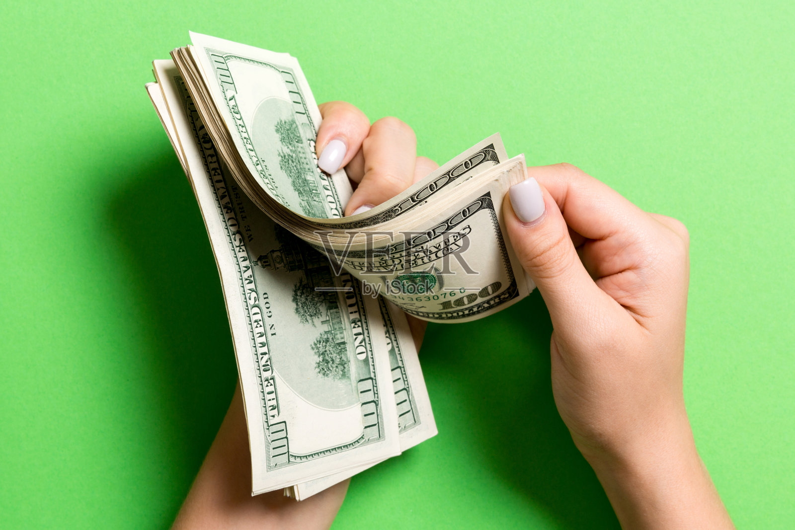 女商人的手在彩色背景上数着一百元钞票。工资和工资概念。俯视图的投资概念照片摄影图片