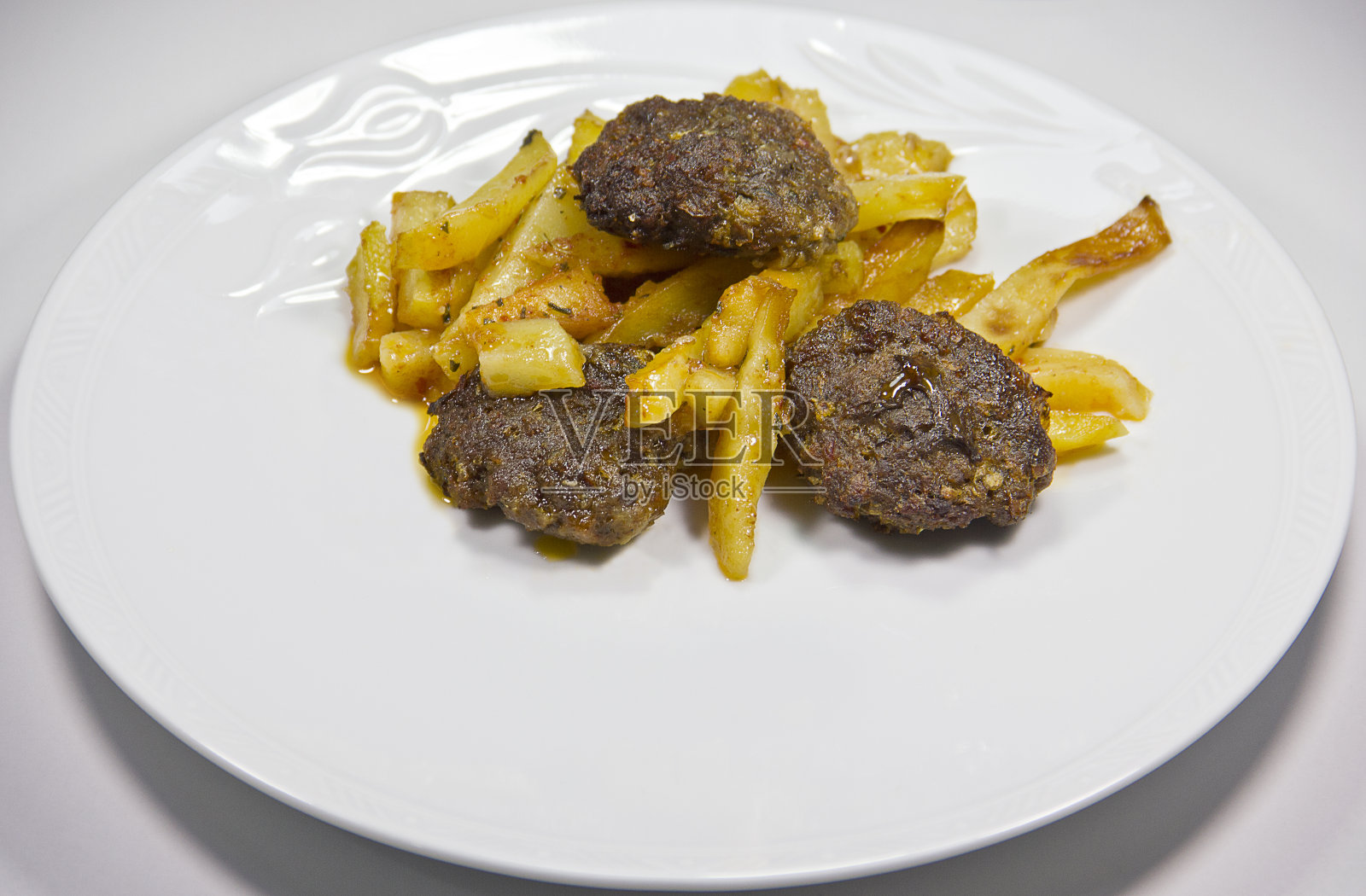 盘子里有肉丸和炸薯条照片摄影图片