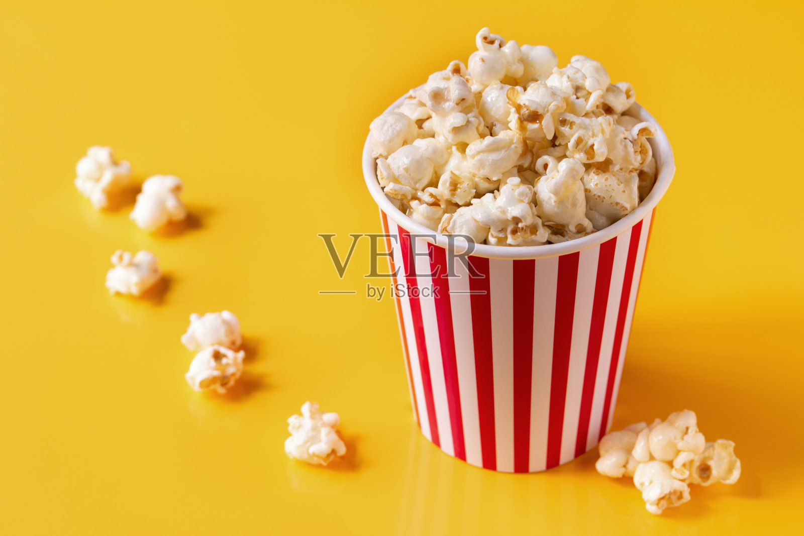 爆玉米花影院盒与玉米桶上黄色隔离照片摄影图片
