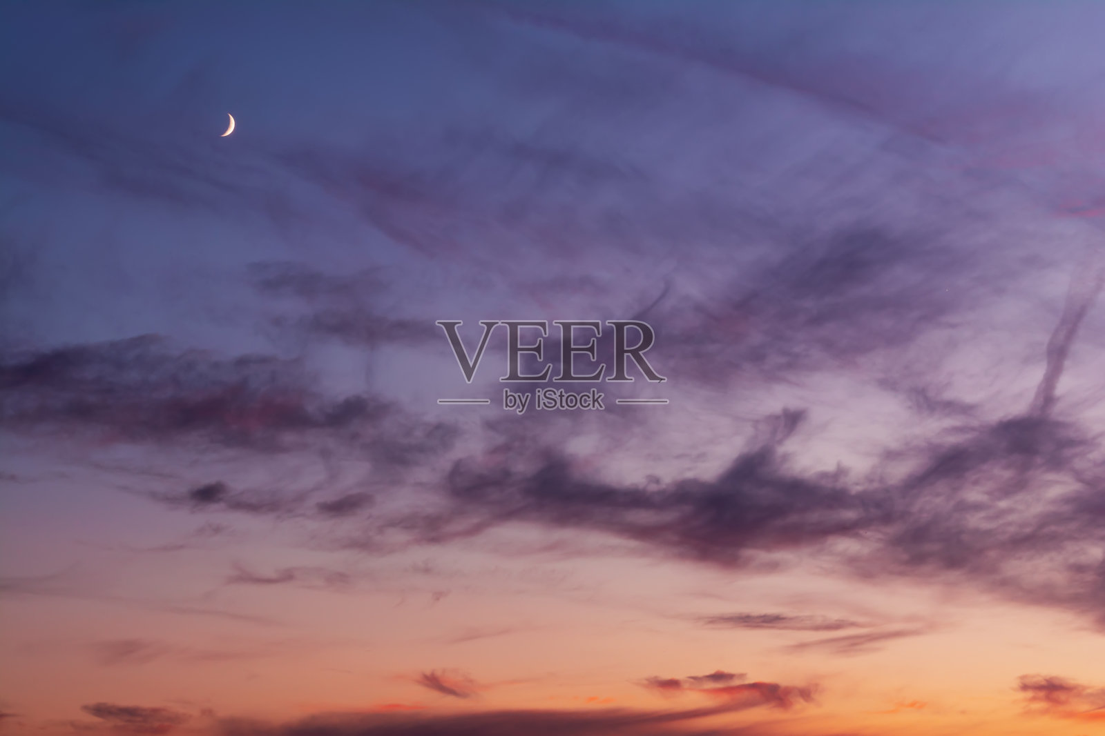 日落时，月亮的天空呈现出鲜艳的橙红色和紫色照片摄影图片