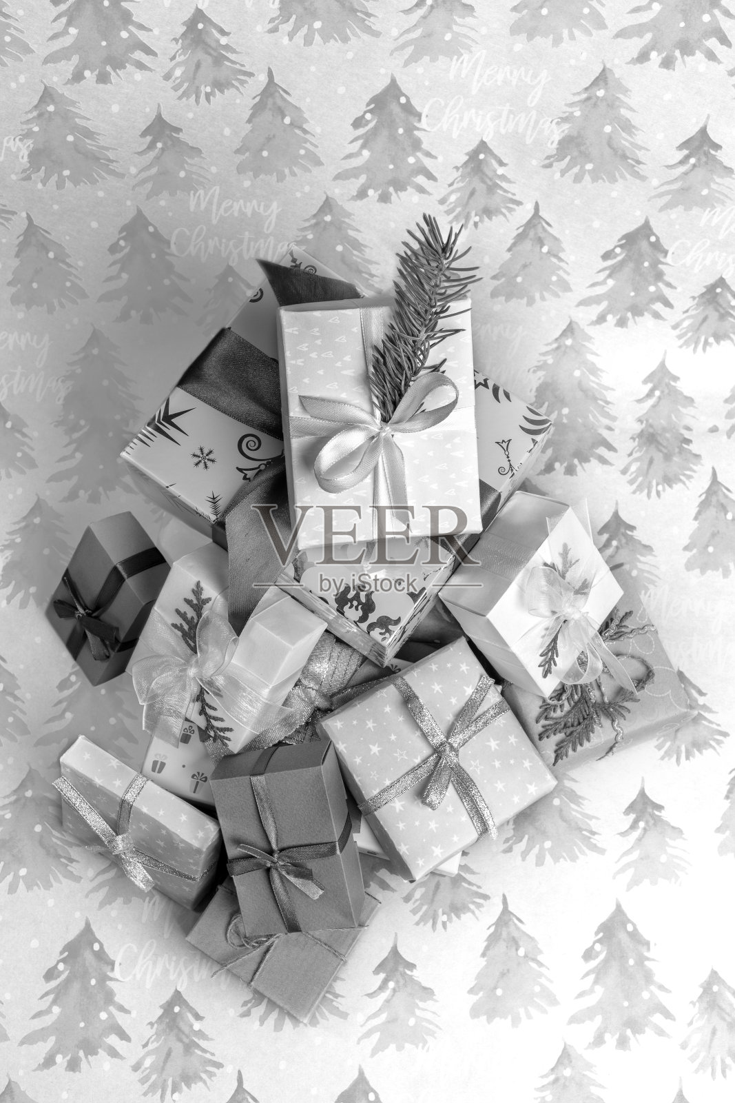 俯视图堆圣诞DIY礼盒节日包装纸与云杉和题词圣诞快乐。照片摄影图片