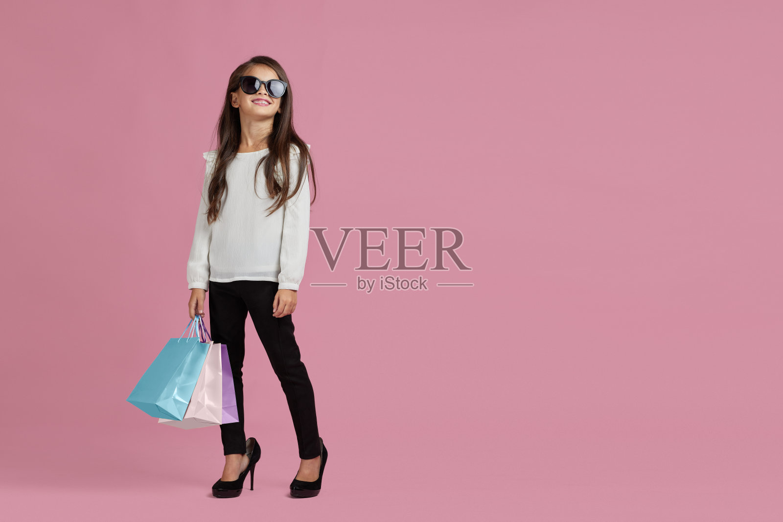 戴墨镜的小女孩拿着购物袋照片摄影图片