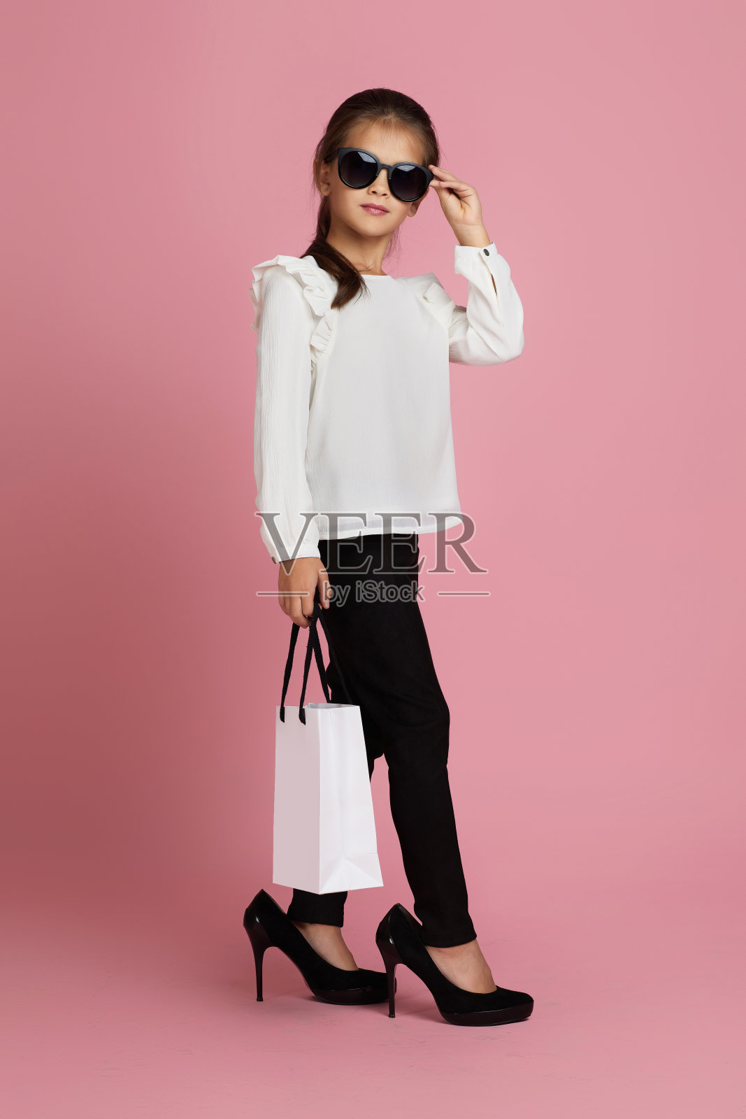 戴墨镜的小女孩拿着购物袋照片摄影图片