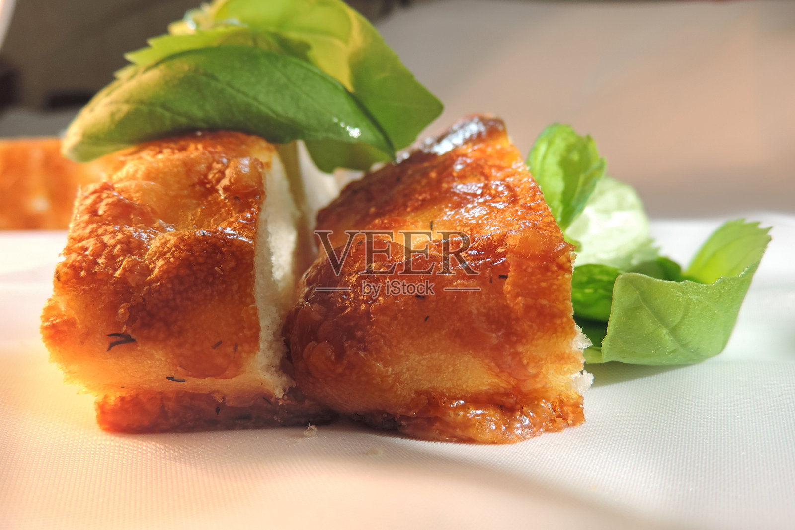 两片美味的面包或馅饼，上面覆盖着烤融化的奶酪和新鲜的罗勒叶照片摄影图片