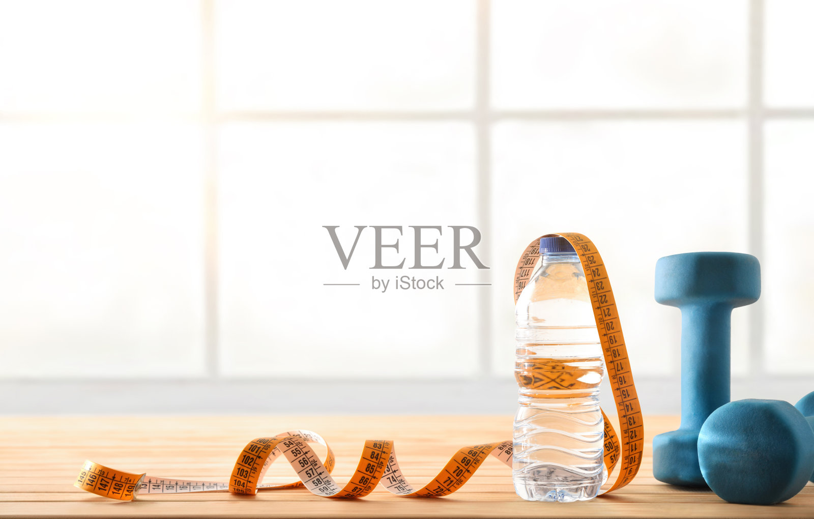 哑铃水瓶和带窗户的镶木地板胶带照片摄影图片