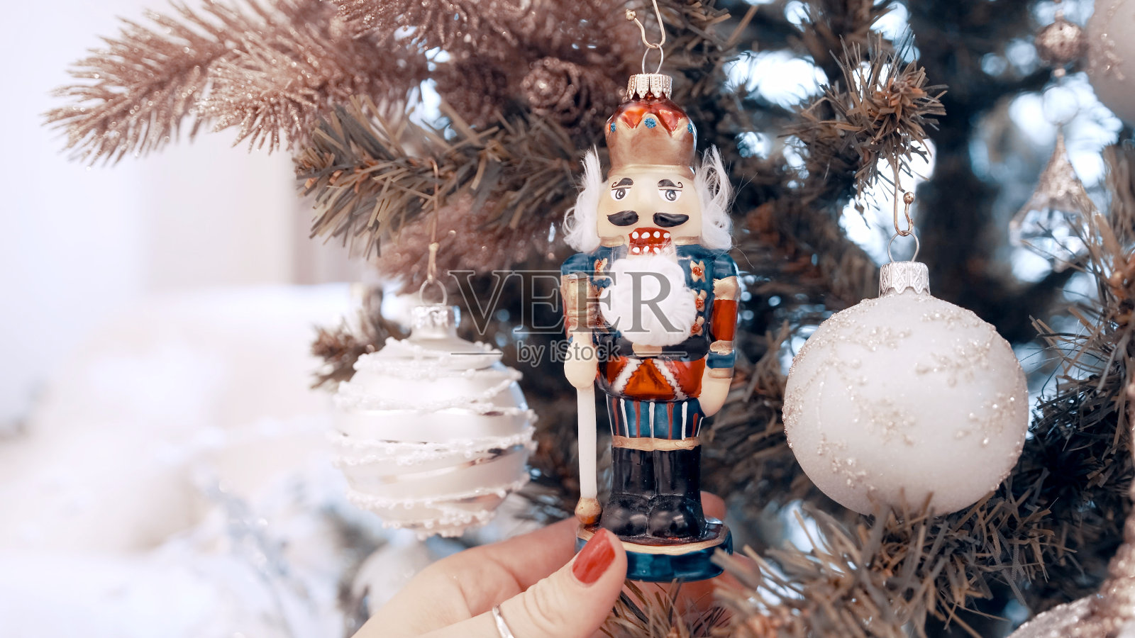 家里的圣诞树上挂着漂亮的浅色玩具。胡桃夹子照片摄影图片