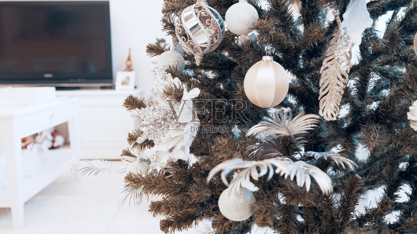 女性用手在家里用玩具装饰圣诞树。美丽的圣诞玩具照片摄影图片