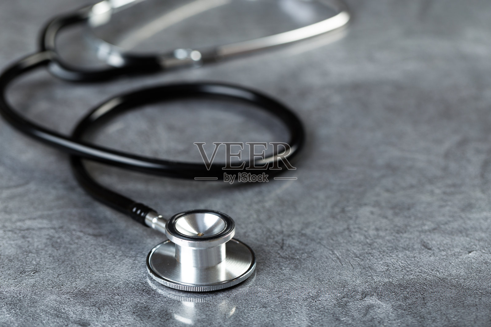 健康实验室医学检查用的黑色带光泽背景反射的听诊器照片摄影图片