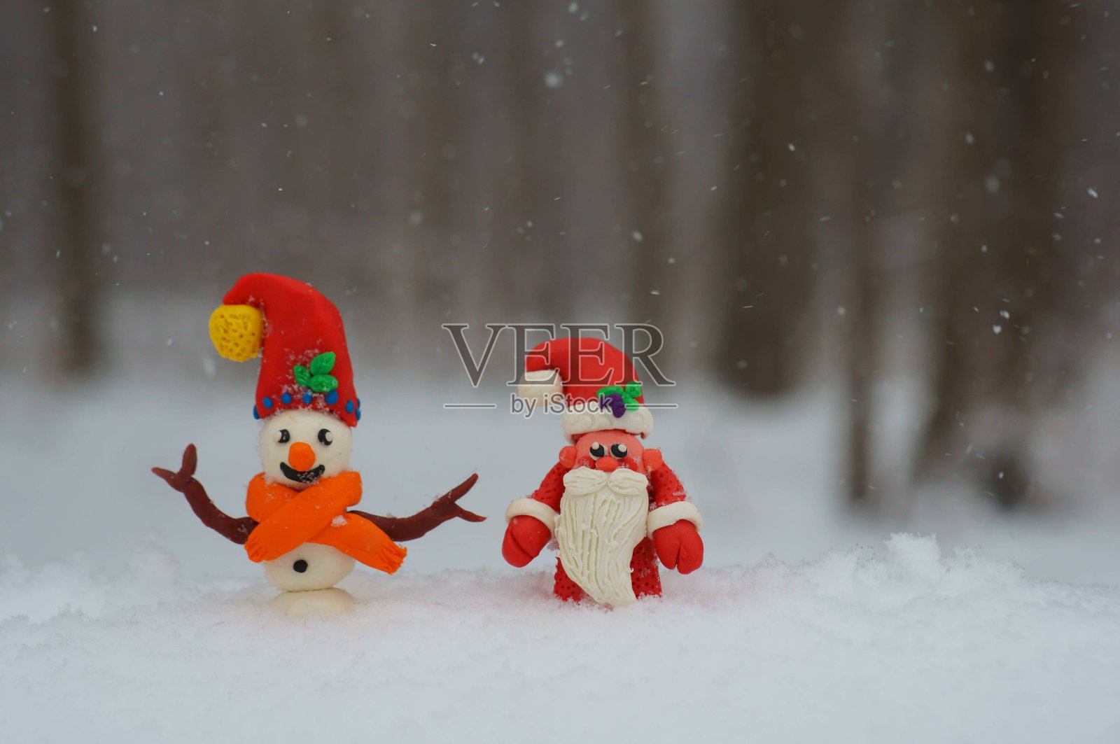 圣诞老人和雪人的身影在白雪的背景上。照片摄影图片