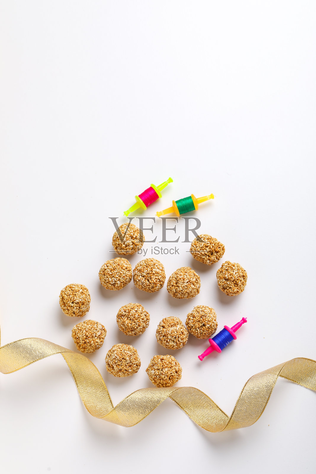 印度节日马卡尔桑格拉提的概念:白色背景上的提尔古尔和芝麻种子球或laddo照片摄影图片