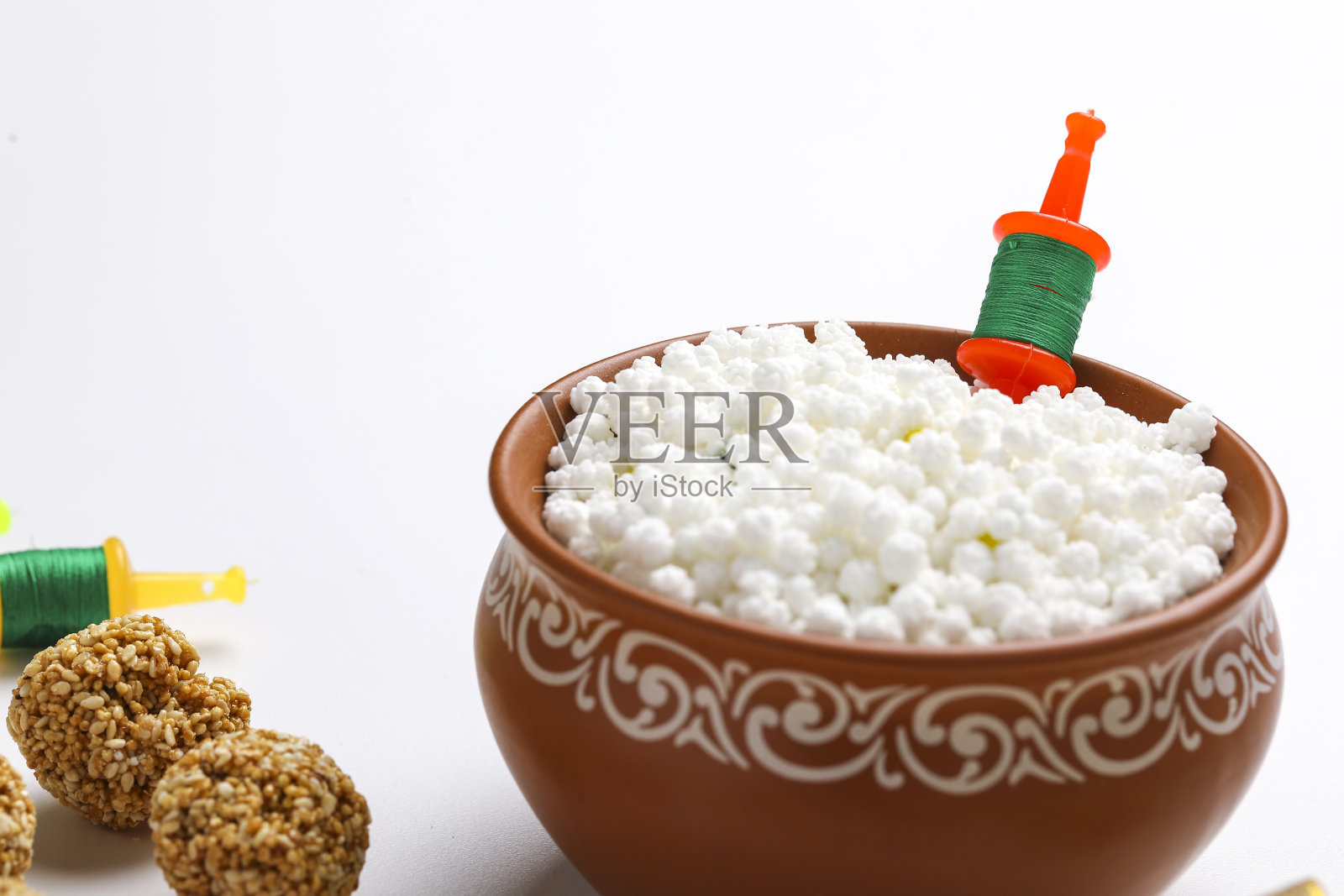 印度节日马卡尔桑格拉提的概念:白色背景上的提尔古尔和芝麻种子球或laddo照片摄影图片