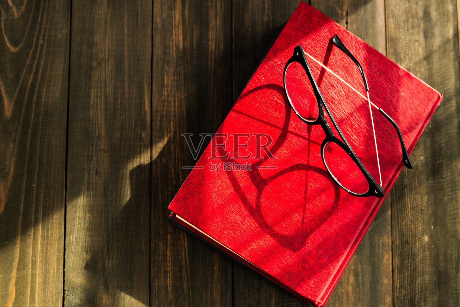 老花镜放在精装书上照片摄影图片