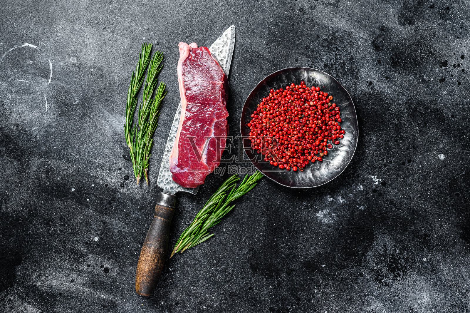 生的大理石牛肉用刀切腰肉排。黑色背景。俯视图照片摄影图片