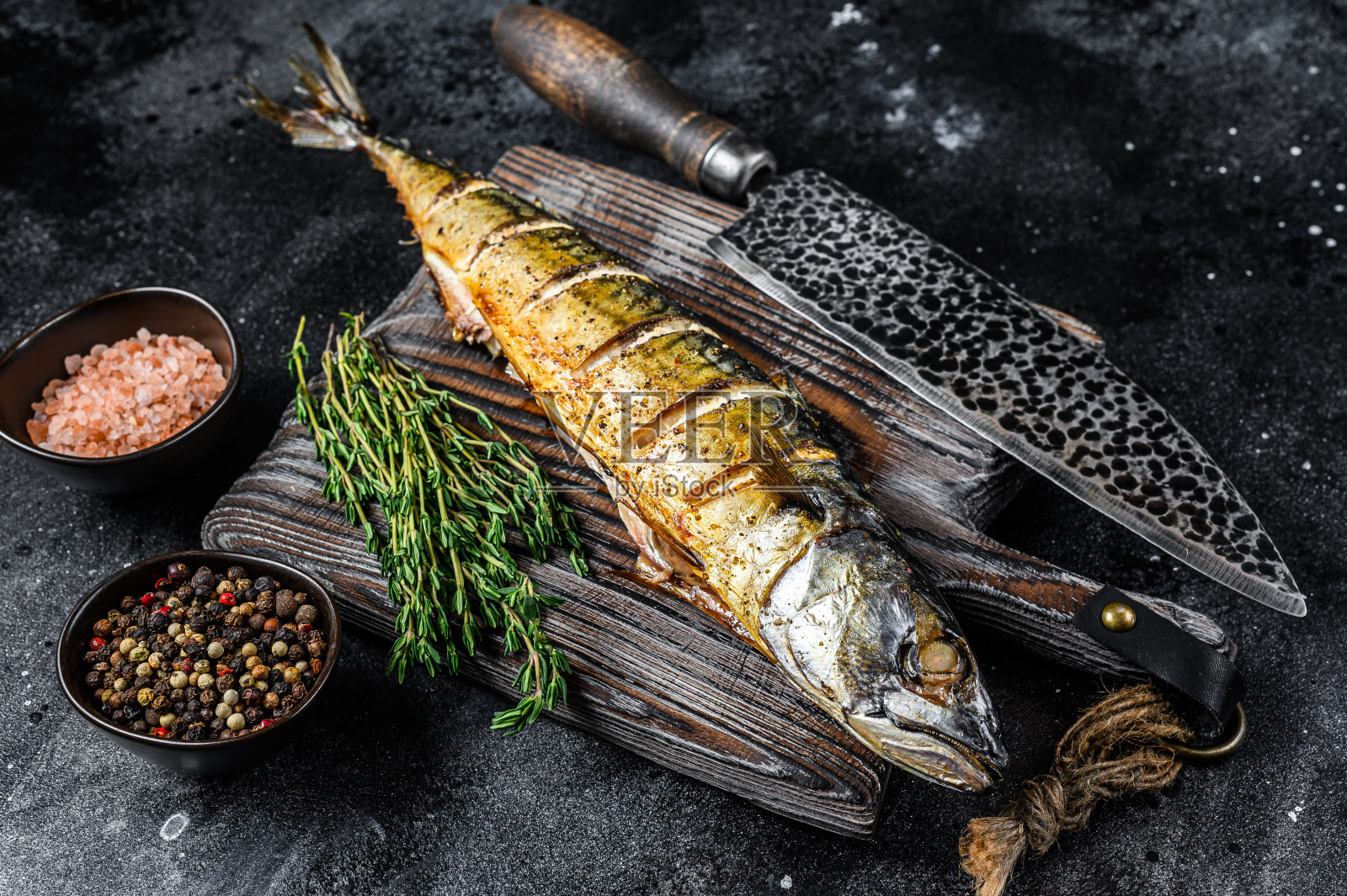 烤鲭鱼配香草。黑色背景。俯视图照片摄影图片
