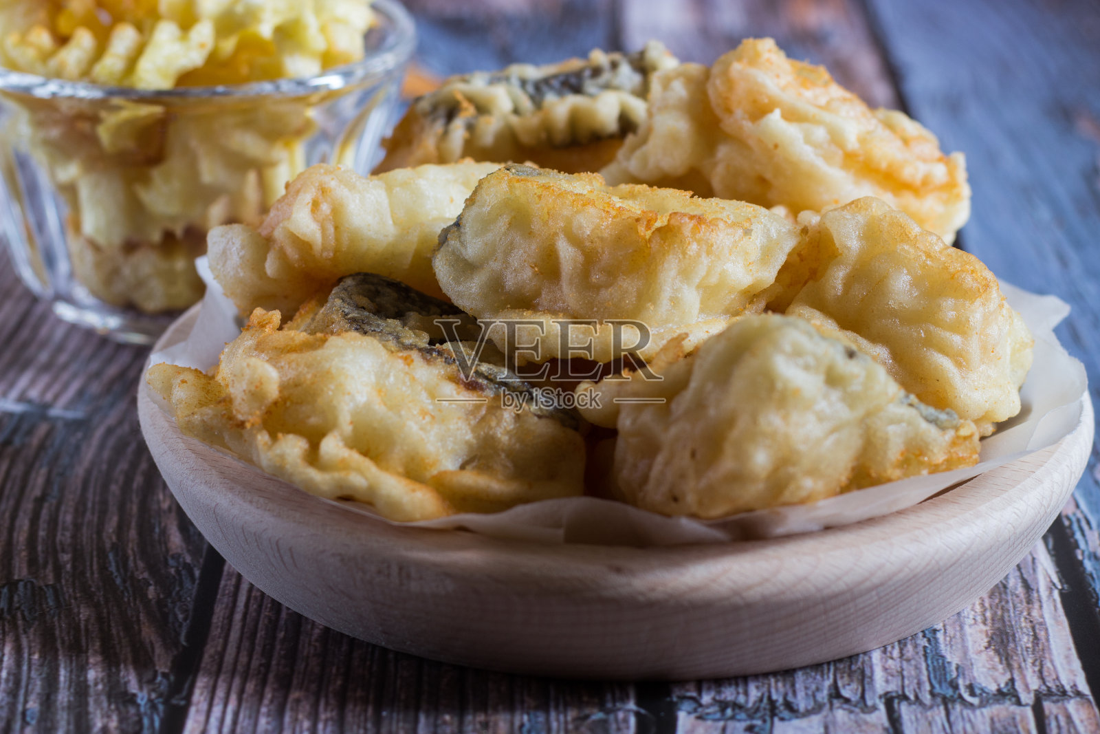 炸过的鳕鱼和炸过的土豆在木背景。有选择性的重点。照片摄影图片