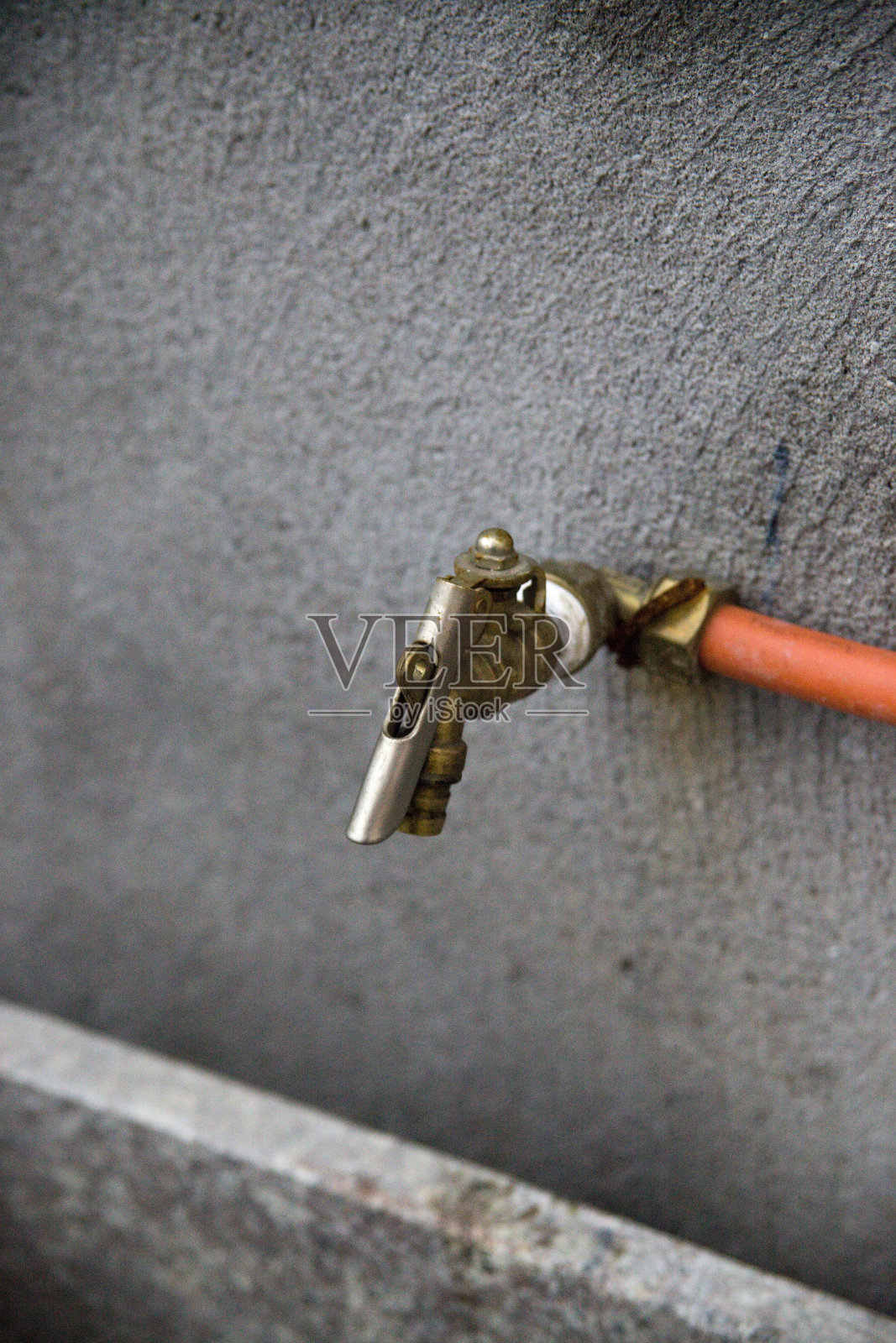 灰色水泥墙上的水龙头照片摄影图片