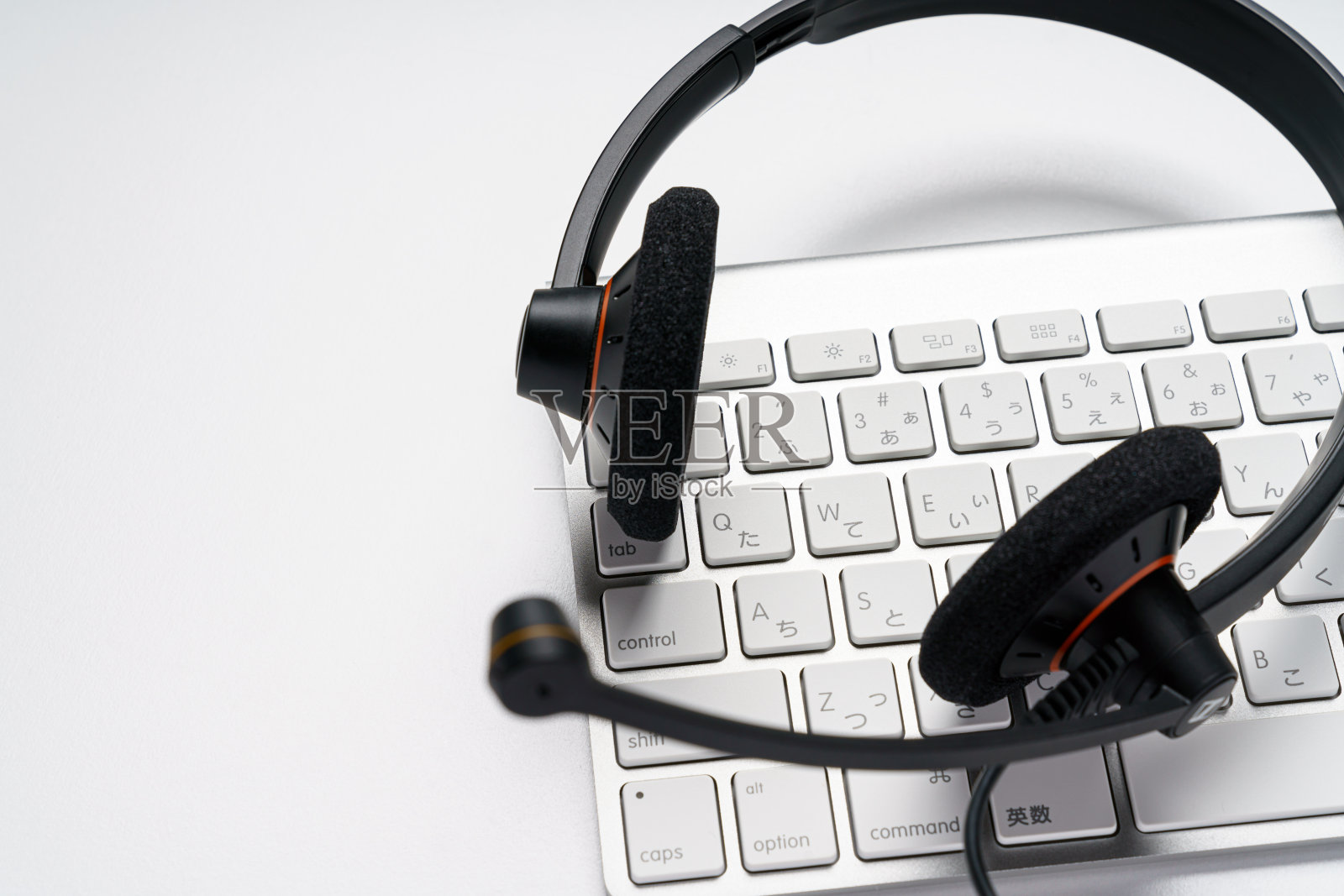 白色背景上的耳机和电脑键盘照片摄影图片