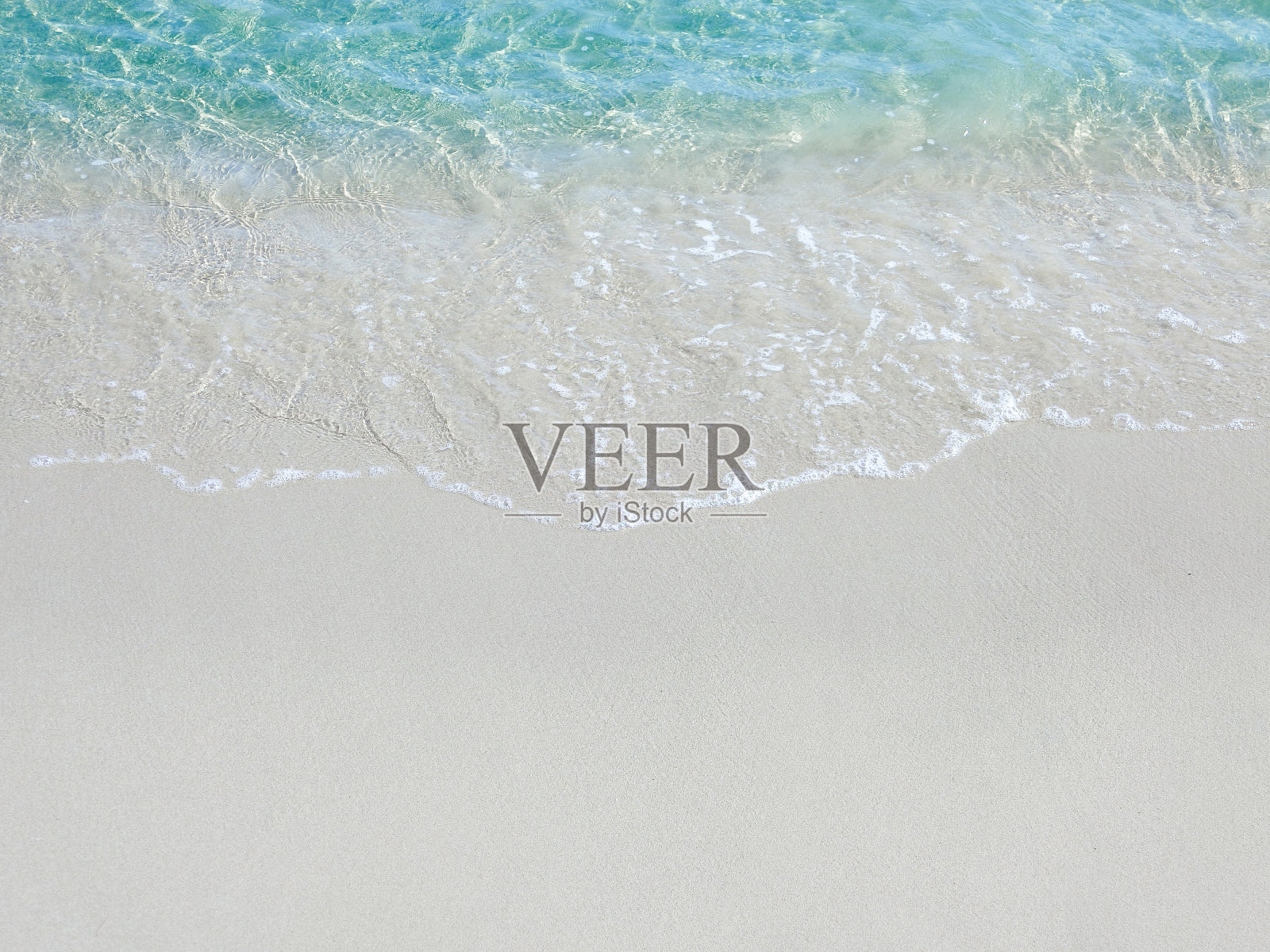 沙滩上冒着泡沫的波浪照片摄影图片