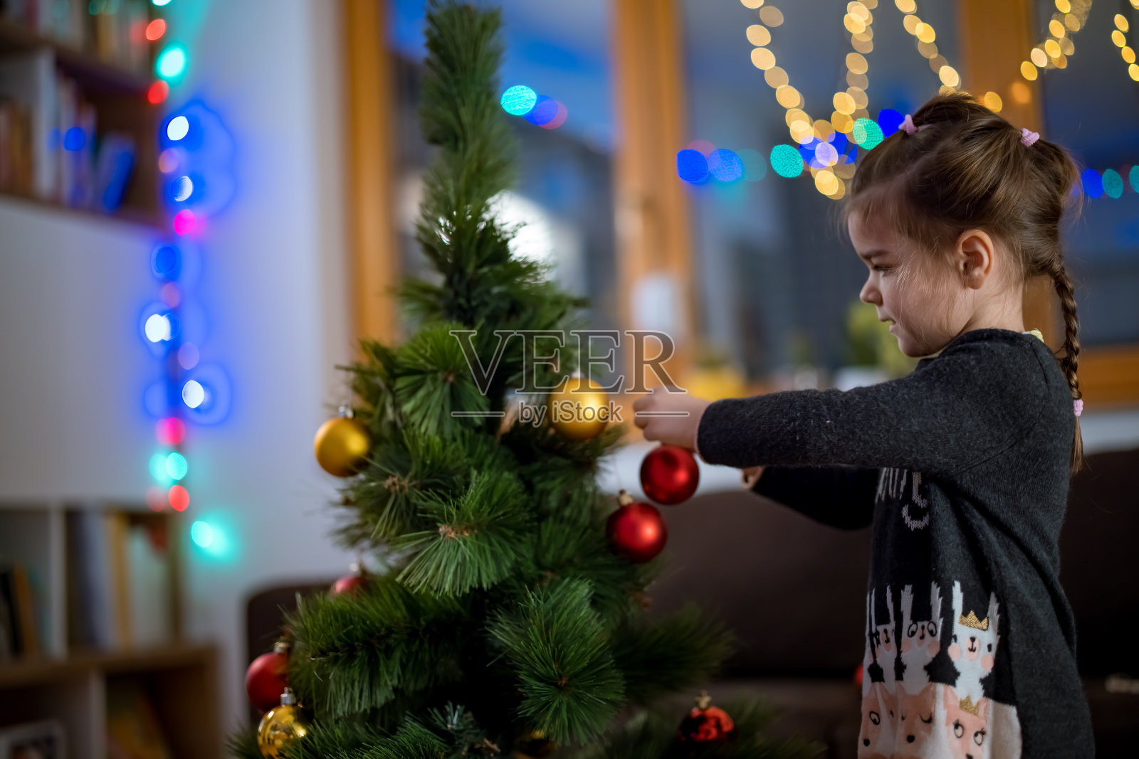 小女孩装饰圣诞树照片摄影图片