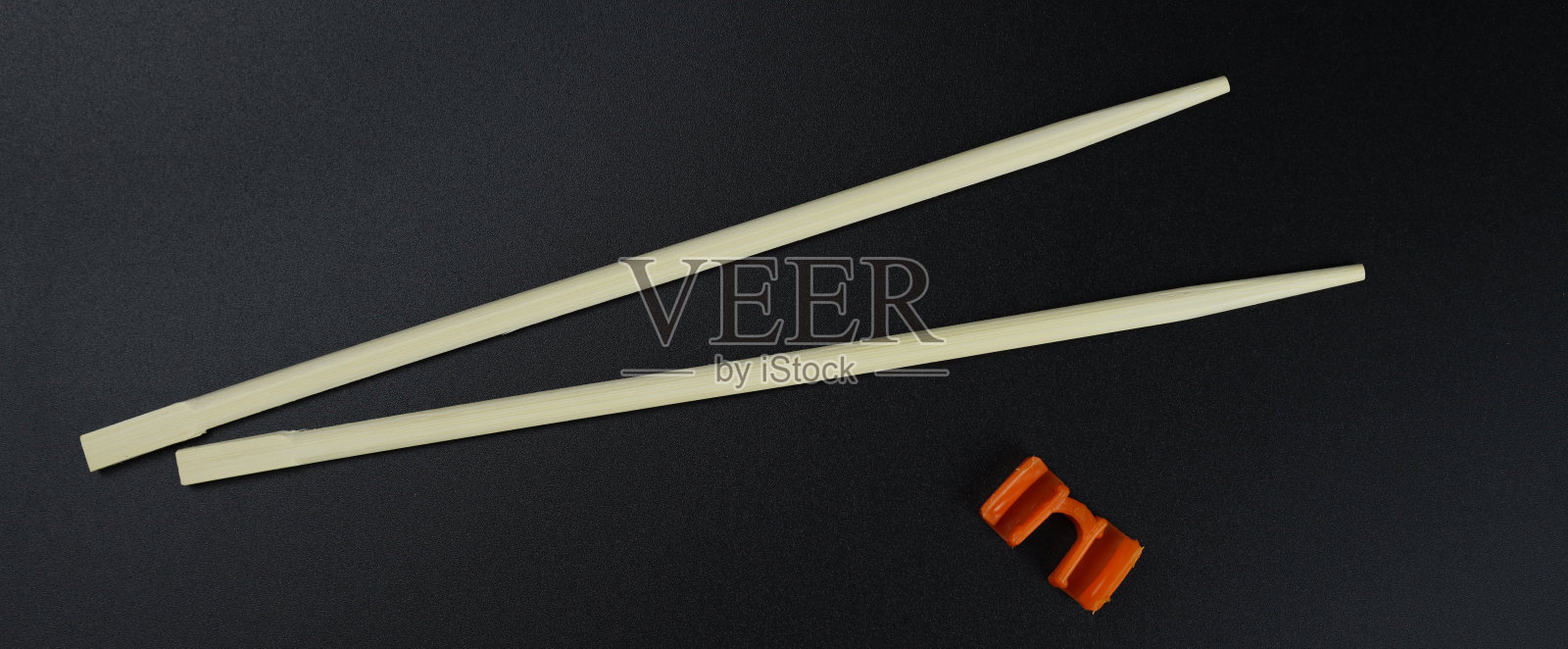 训练用木制筷子，寿司棒放在黑色的背景上照片摄影图片