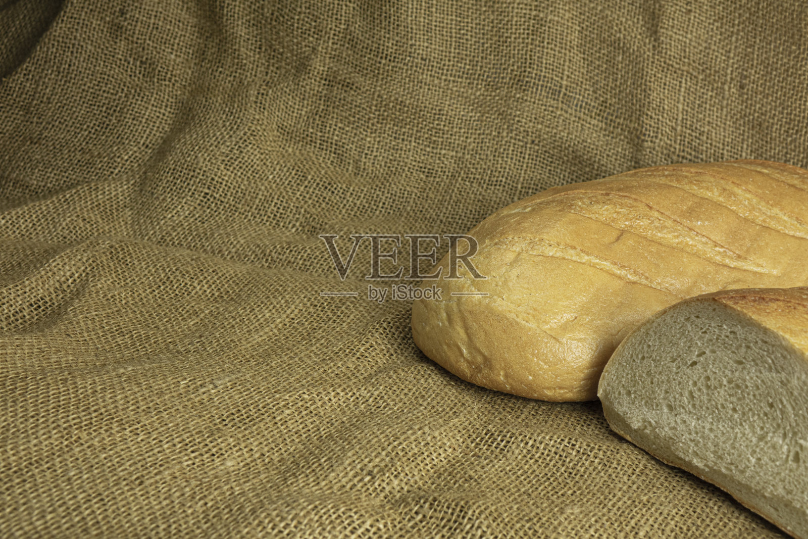 新鲜手工面包在麻袋布背景照片摄影图片
