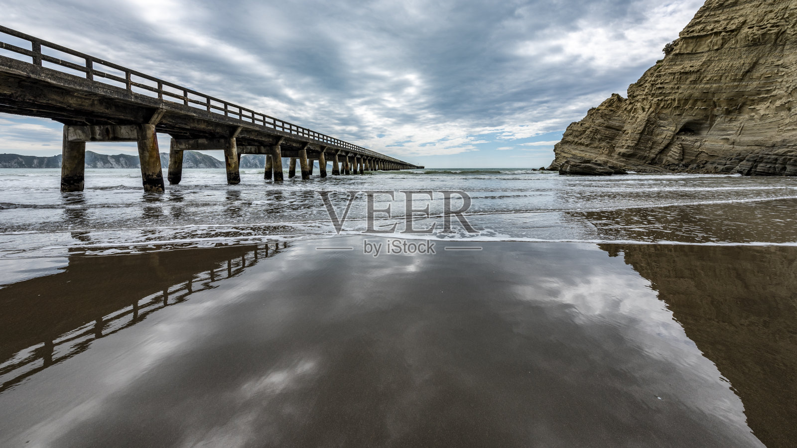 码头在多云的天空下延伸入海照片摄影图片