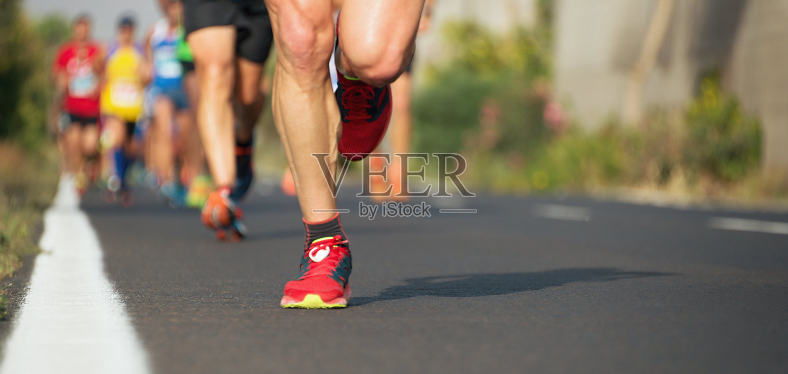 马拉松赛跑，跑步者的脚在路上照片摄影图片