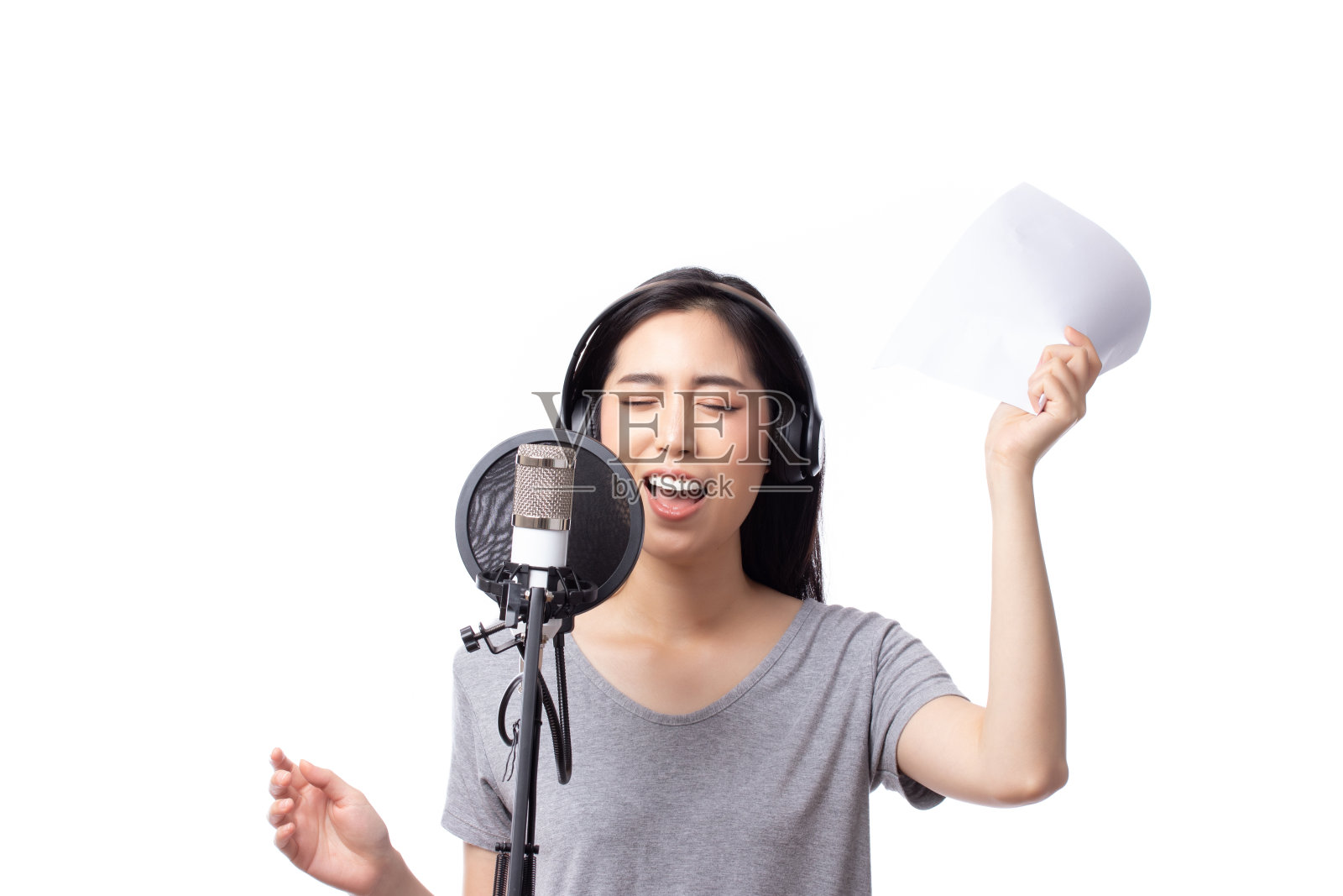 歌手亚洲女人用麦克风和读歌词在音乐工作室快乐的表情脸孤立在白色的背景。照片摄影图片