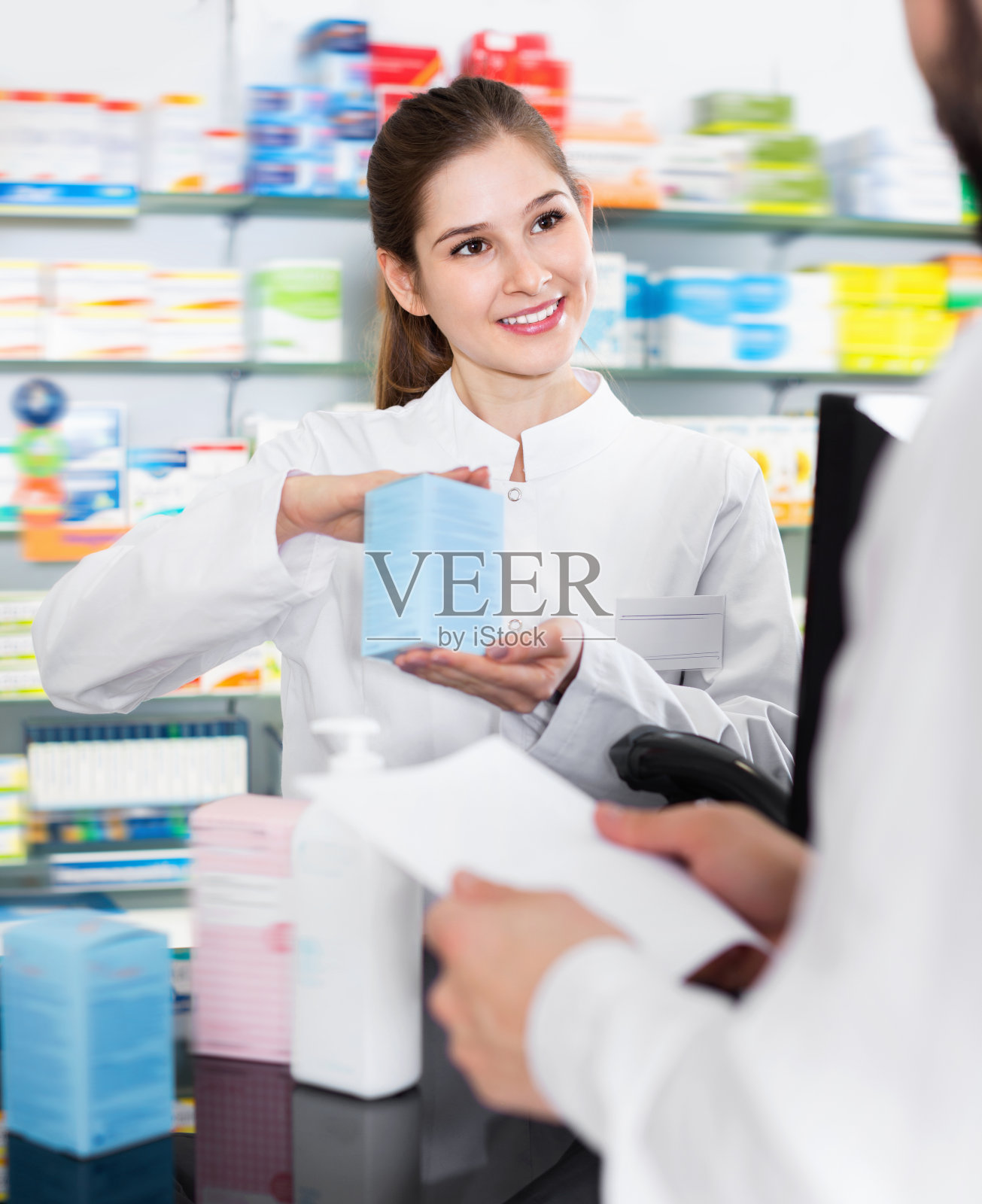 女药剂师在药剂师里为男病人推荐药。照片摄影图片