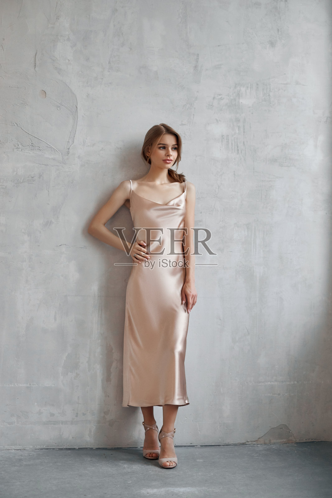 穿着浅米色丝绸连衣裙的漂亮性感女人。噪音，焦点模糊照片摄影图片