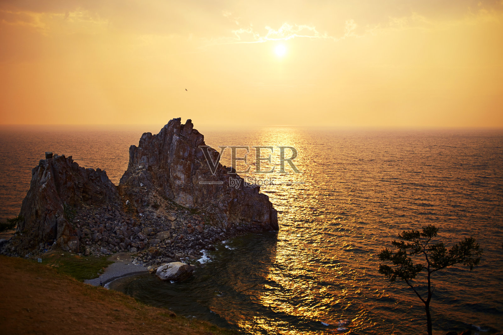 贝加尔湖上美丽的日落。观赏萨满岩或布尔汗角在奥尔孔岛。照片摄影图片