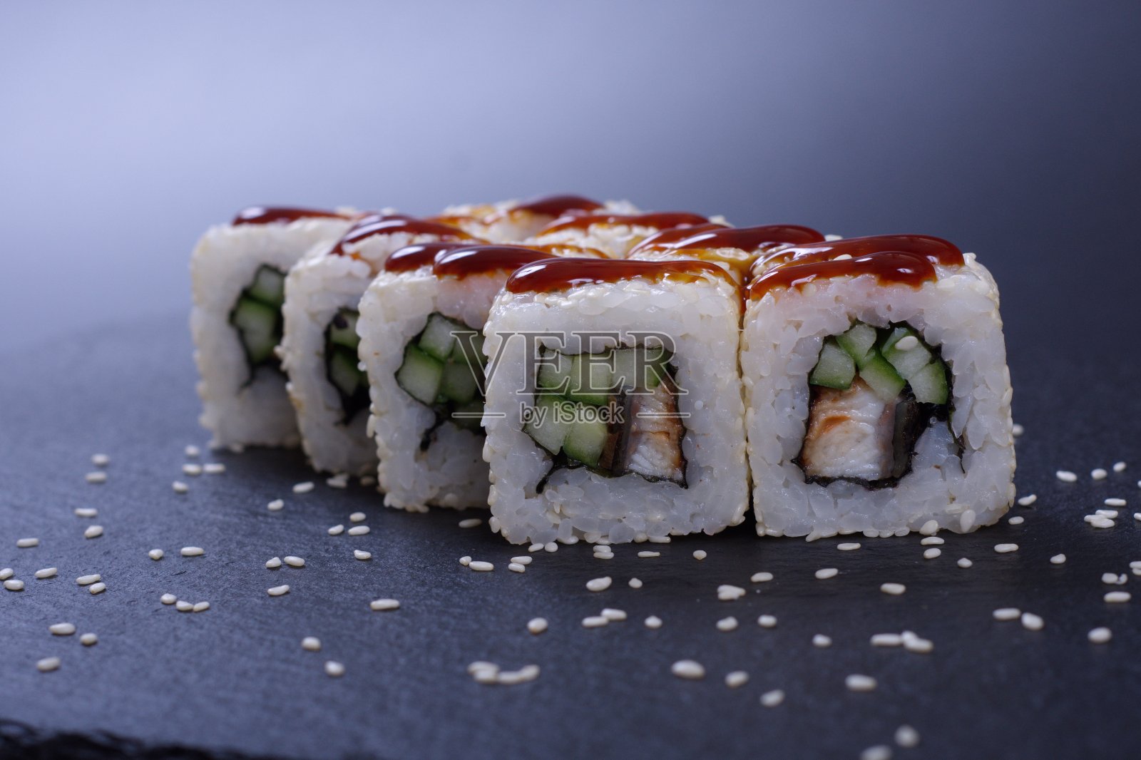 黑色的石头上放着五颜六色的海鲜卷和米饭照片摄影图片