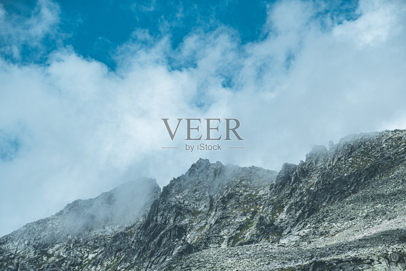 碧蓝的天空，云雾缭绕的岩石，美丽的云雾缭绕的山脉照片摄影图片