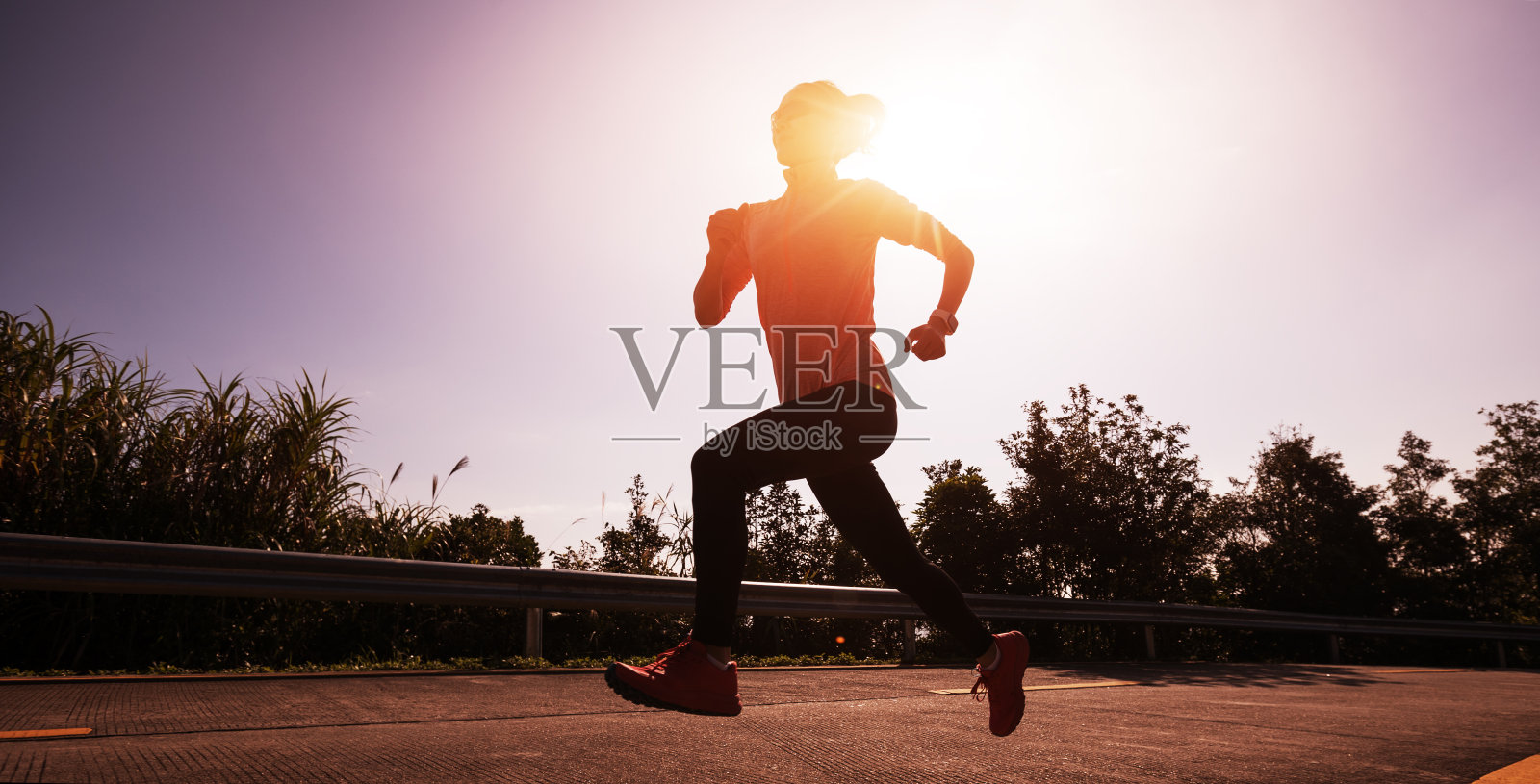 冬天的一天，女跑步者在日出的山顶上跑步照片摄影图片