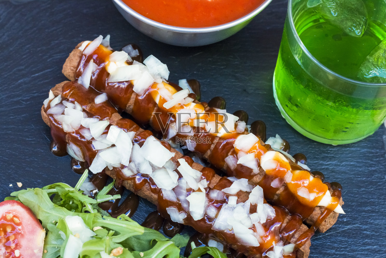 脆炸香肠或热狗，加蛋黄酱、番茄酱和切碎的洋葱照片摄影图片