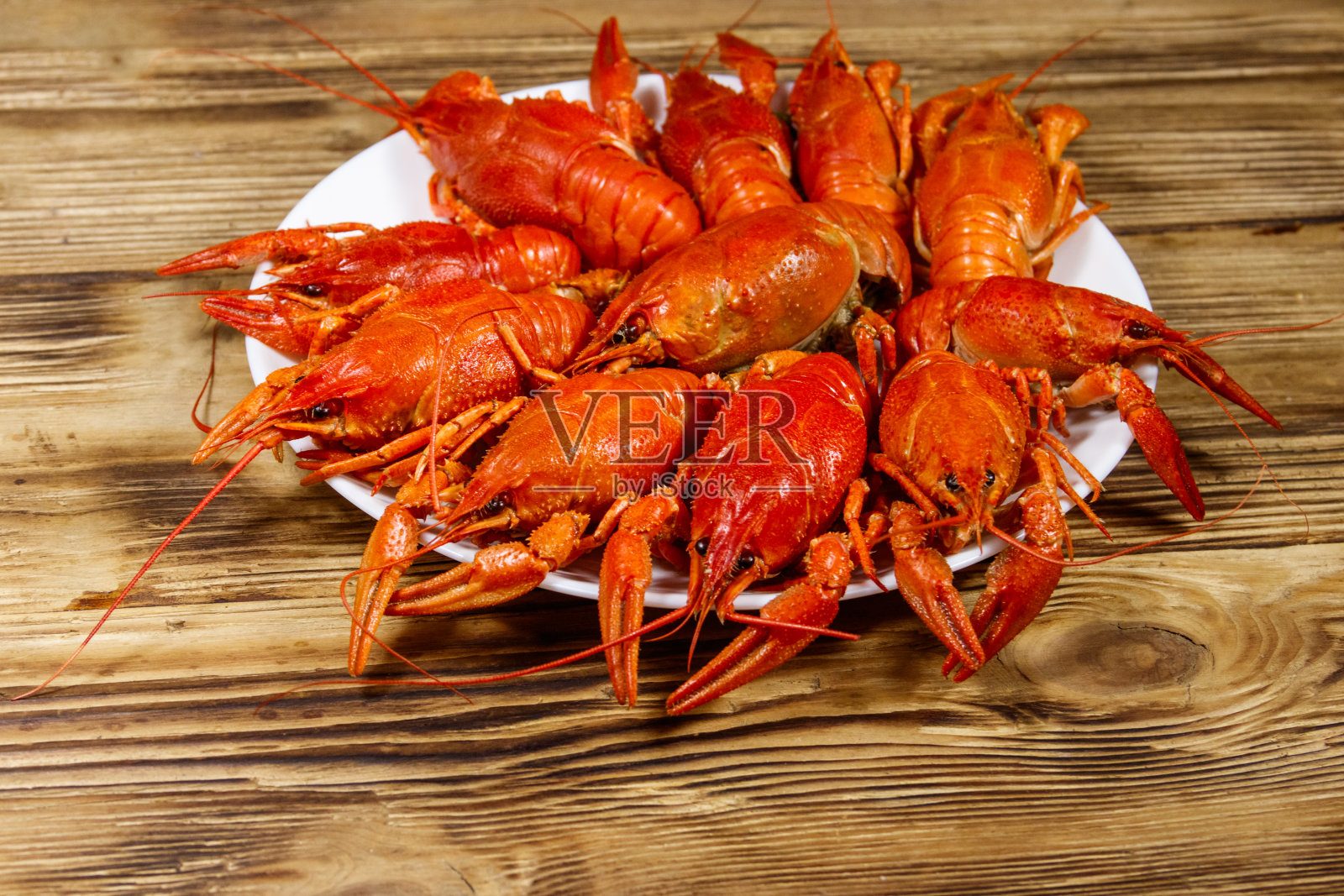 在木桌上的盘子里煮小龙虾照片摄影图片
