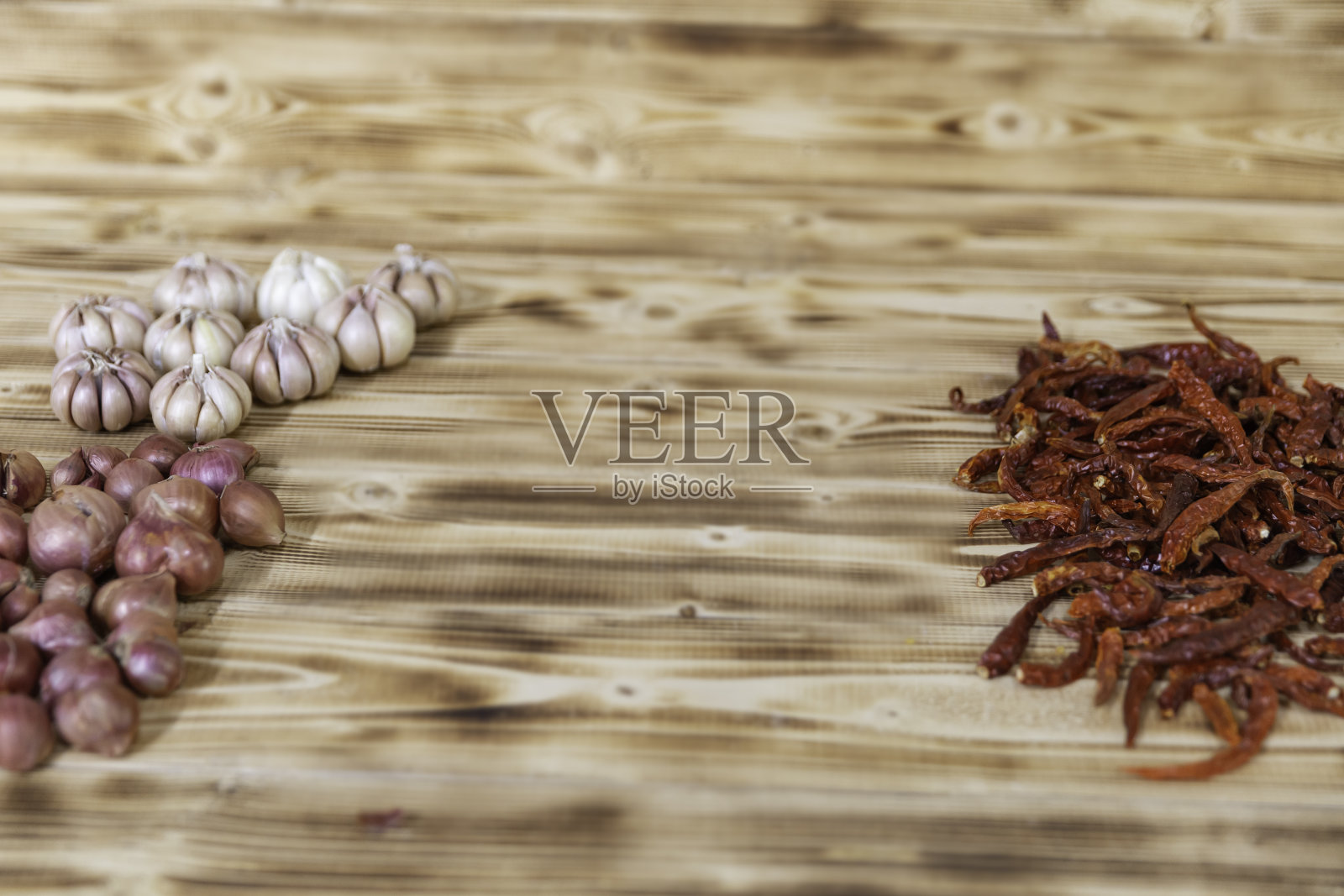 把红葱、干红辣椒和白蒜放在棕色的竹叶上。铺在木板上。他们在厨房准备配料食物。照片摄影图片