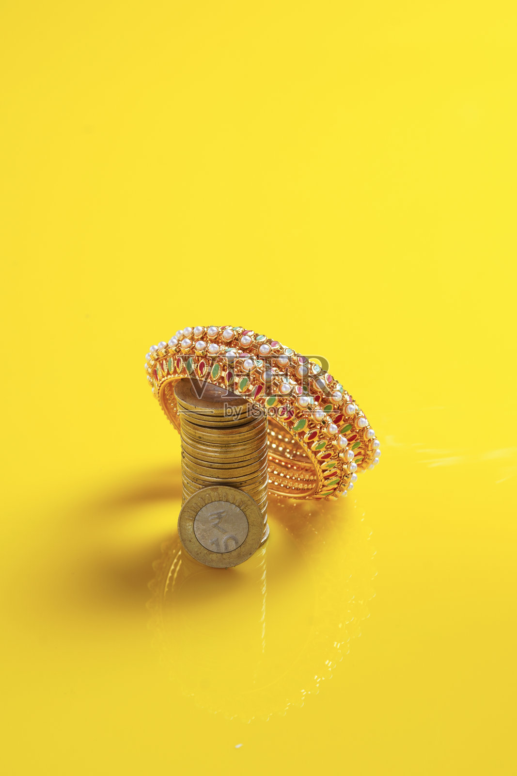 黄金贷款概念:黄金首饰和印度卢比硬币在黄色的背景照片摄影图片