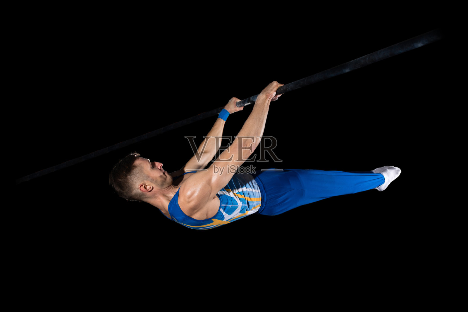 肌肉发达的男子体操运动员在体操馆里训练，灵活、活跃。白种人，穿着蓝色运动服的运动员穿着黑色的衣服照片摄影图片