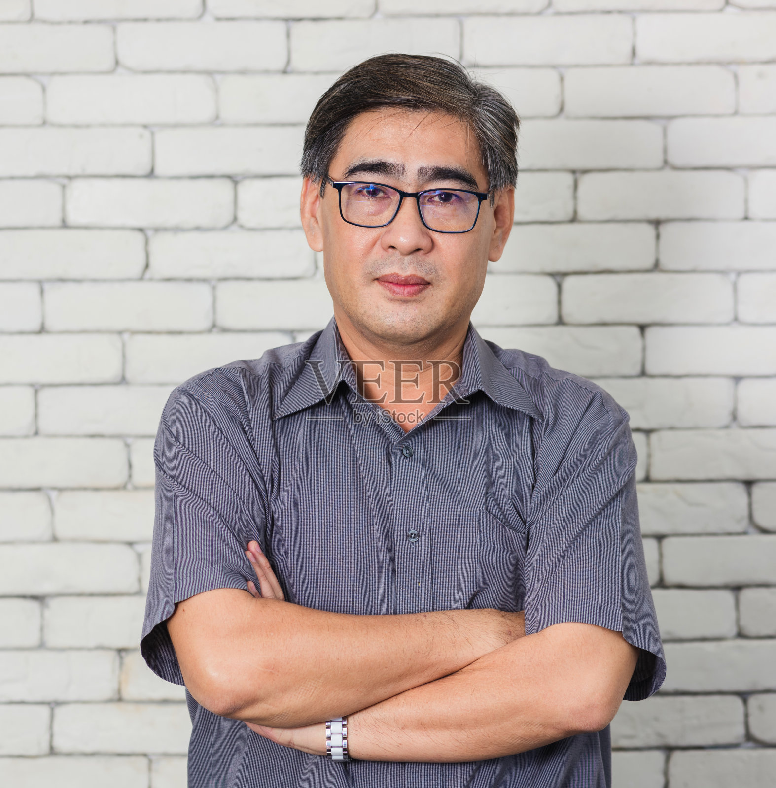 白砖墙背景上是一位老人照片摄影图片