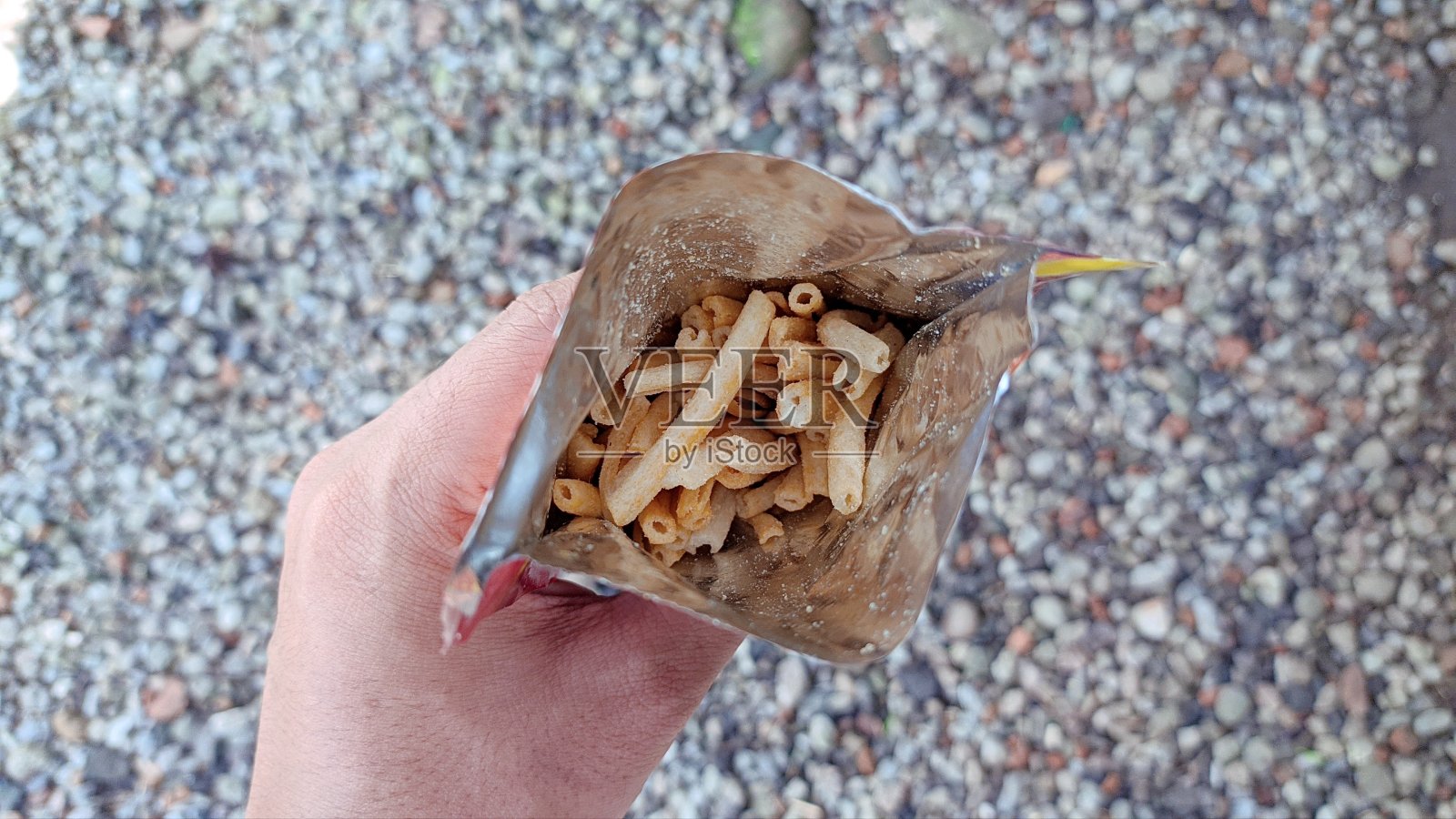 手里拿着一包零食照片摄影图片