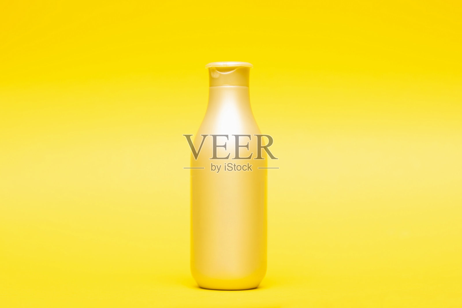 黄色背景的洗发香波和护发素照片摄影图片