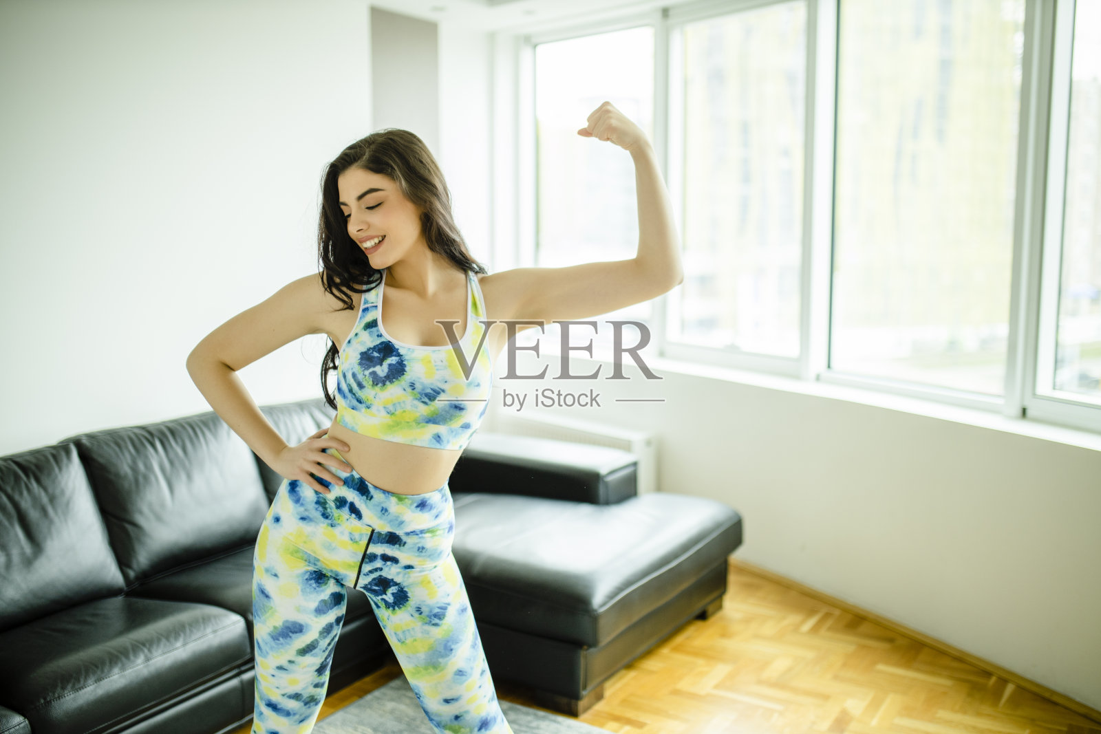 快乐的年轻妇女穿着运动服在家锻炼的肖像照片摄影图片