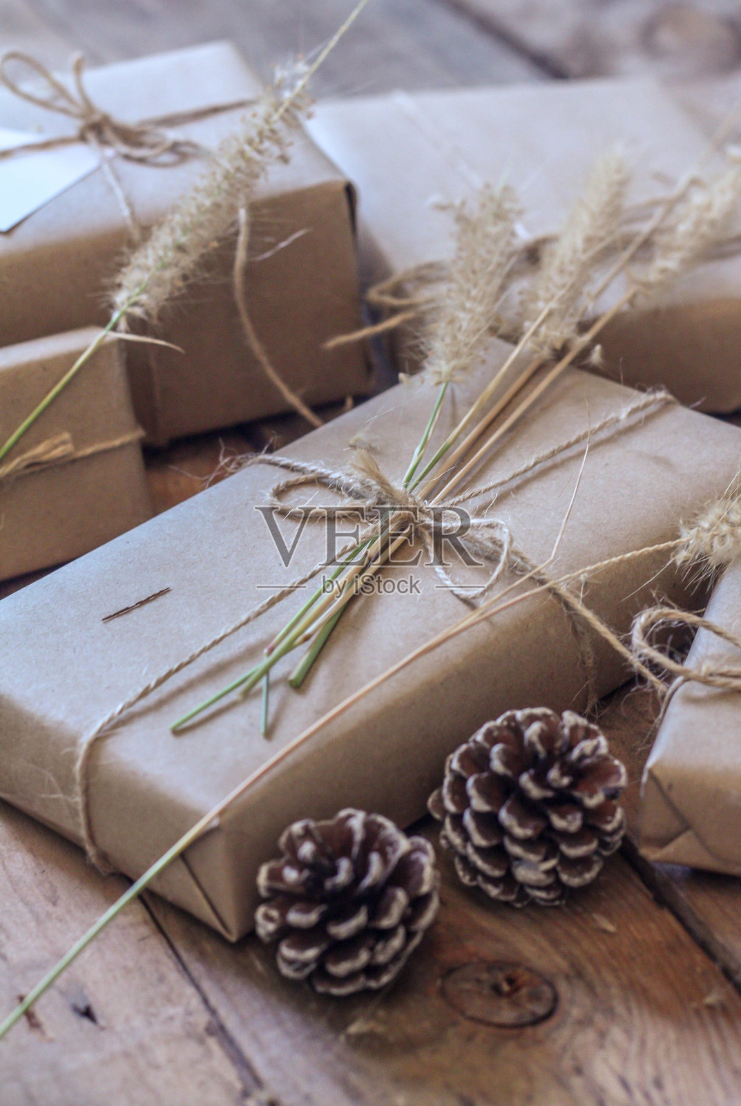 圣诞礼品盒用棕色的再生纸和记事本放在木桌上。照片摄影图片