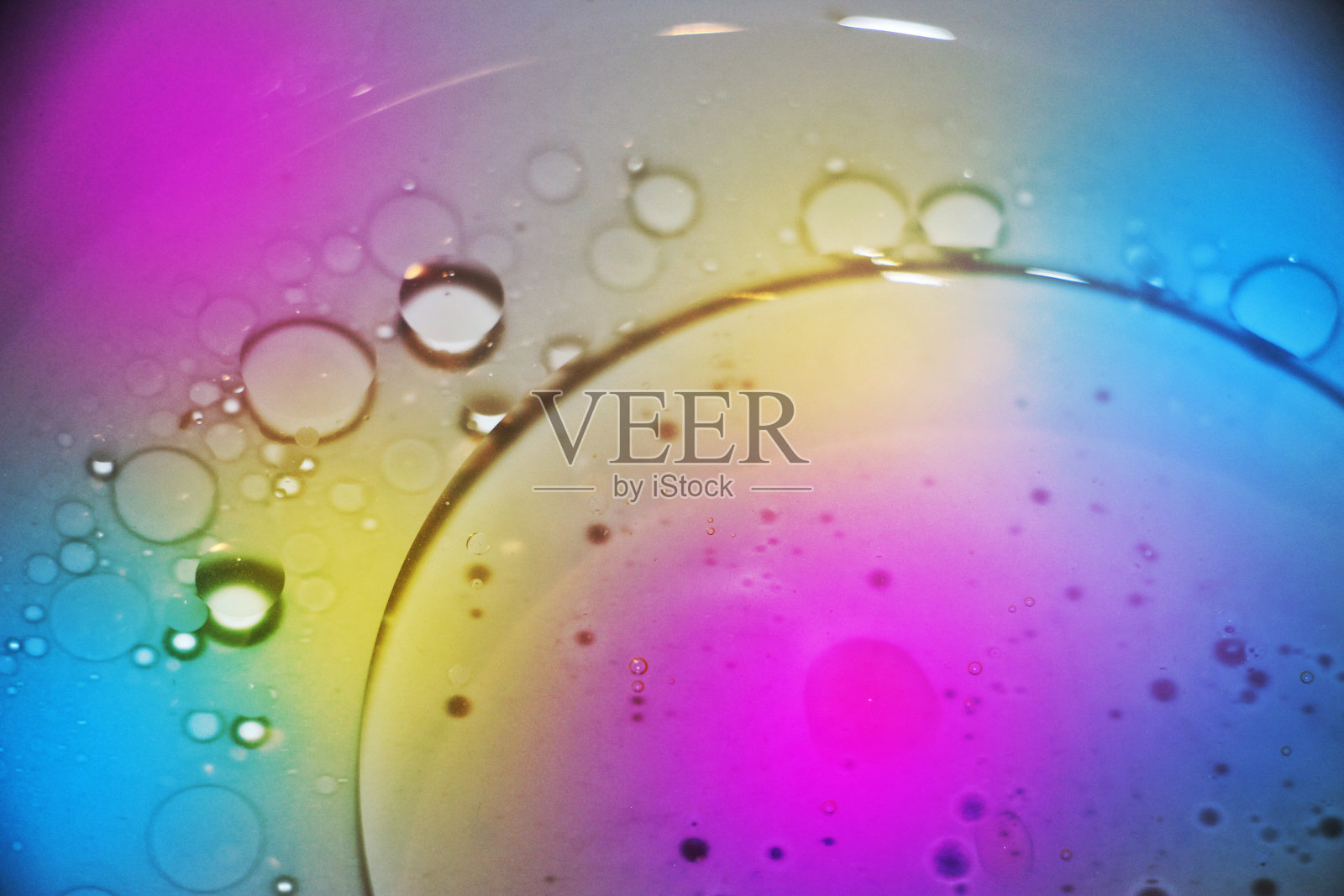 在霓虹灯下，油滴在水面上照片摄影图片