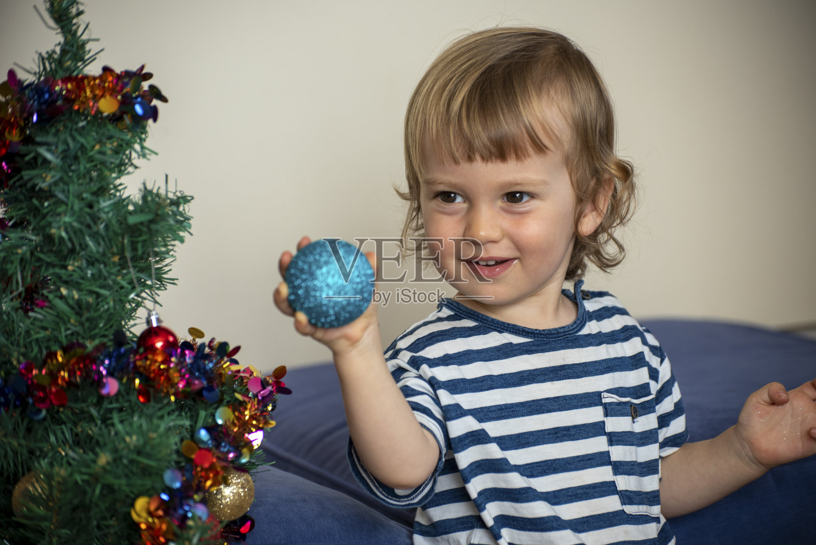 2岁的小男孩在澳大利亚帮忙布置圣诞装饰。照片摄影图片