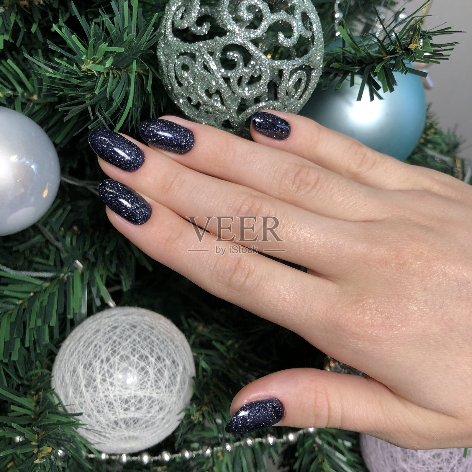 时尚时尚的黑色女性美甲。一个涂着黑色指甲的女人的手照片摄影图片