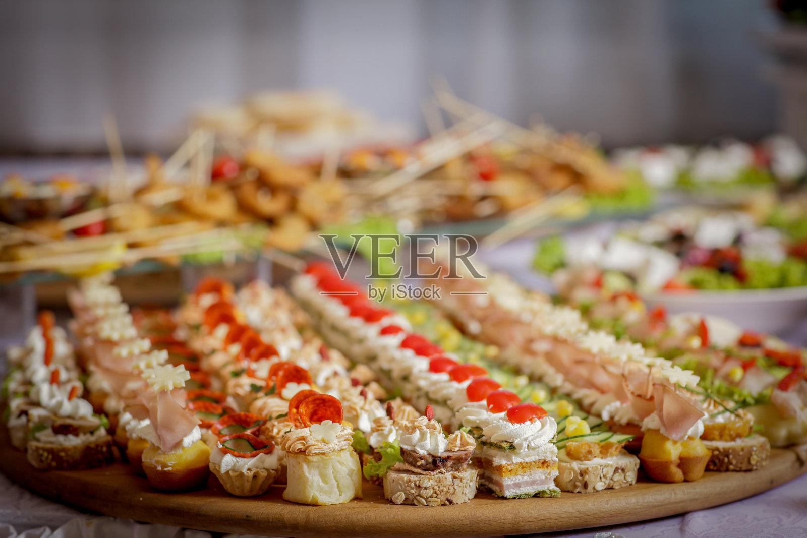 不同类型的蛋糕和颜色在一个木制底座上的桌子与其他蛋糕绝缘照片摄影图片